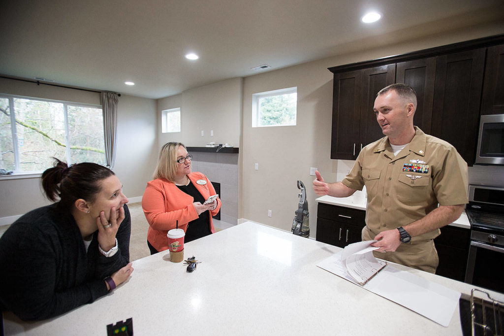 Heather and Tyler Ferrel chat with Courtney McClasky (center), a broker with Keller Williams North Sound Realty in Marysville, in the house they intend to buy in Marysville. (Andy Bronson / The Herald) 
