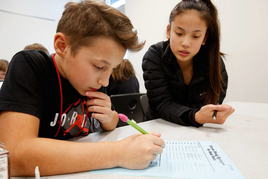 Joseph Fillippov (left) gets help with understanding synonyms from Kamiak High sophomore Connie Chen at the Learning Labs at Olympic View Middle School, a free after-school program for sixth-graders to get an academic boost. (Andy Bronson / The Herald)
