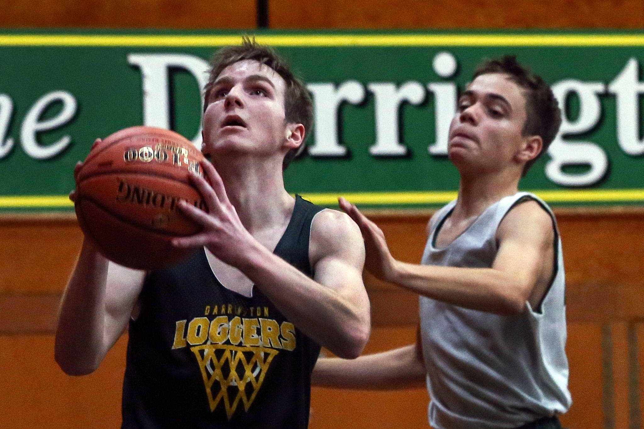 Alex McConnaughy (left) attempts a shot with Shane Jacobs trailing during practice Thursday night at Darrington High School on November 29, 2018. (Kevin Clark / The Herald)