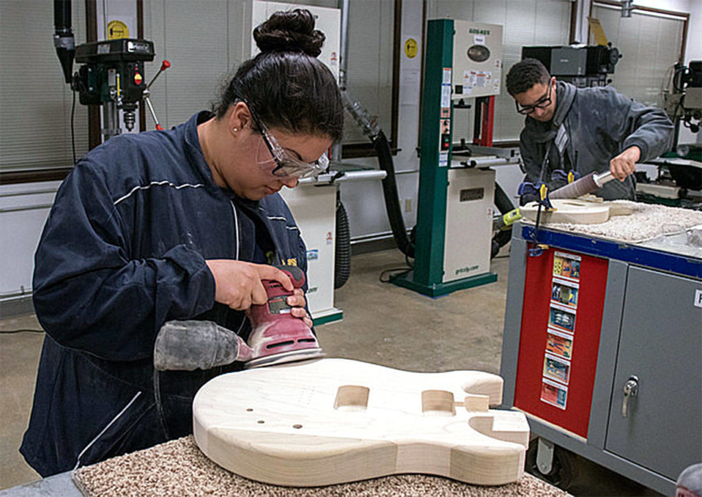 Violet Velazquez works the sander at a workshop hosted by Edmonds Community College in November in recognition of Veterans Day. (Photo by James Huntington Cordero)

