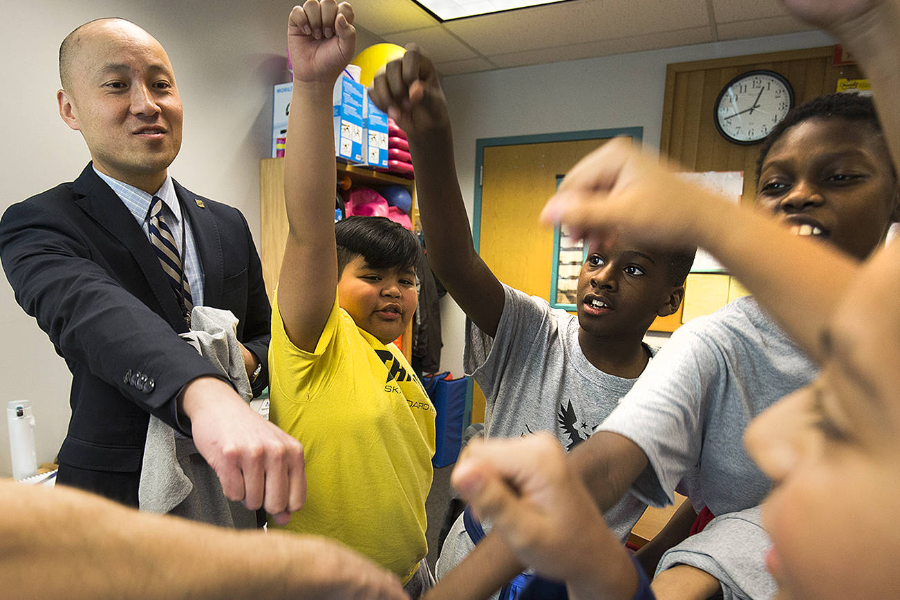 Horizon Elementary School Principal Edmund Wong bumps fists with with students in the Wednesday Boys Club program at the end of the session on Wednesday, Dec. 5, 2018 in Everett, Wa. (Andy Bronson / The Herald)