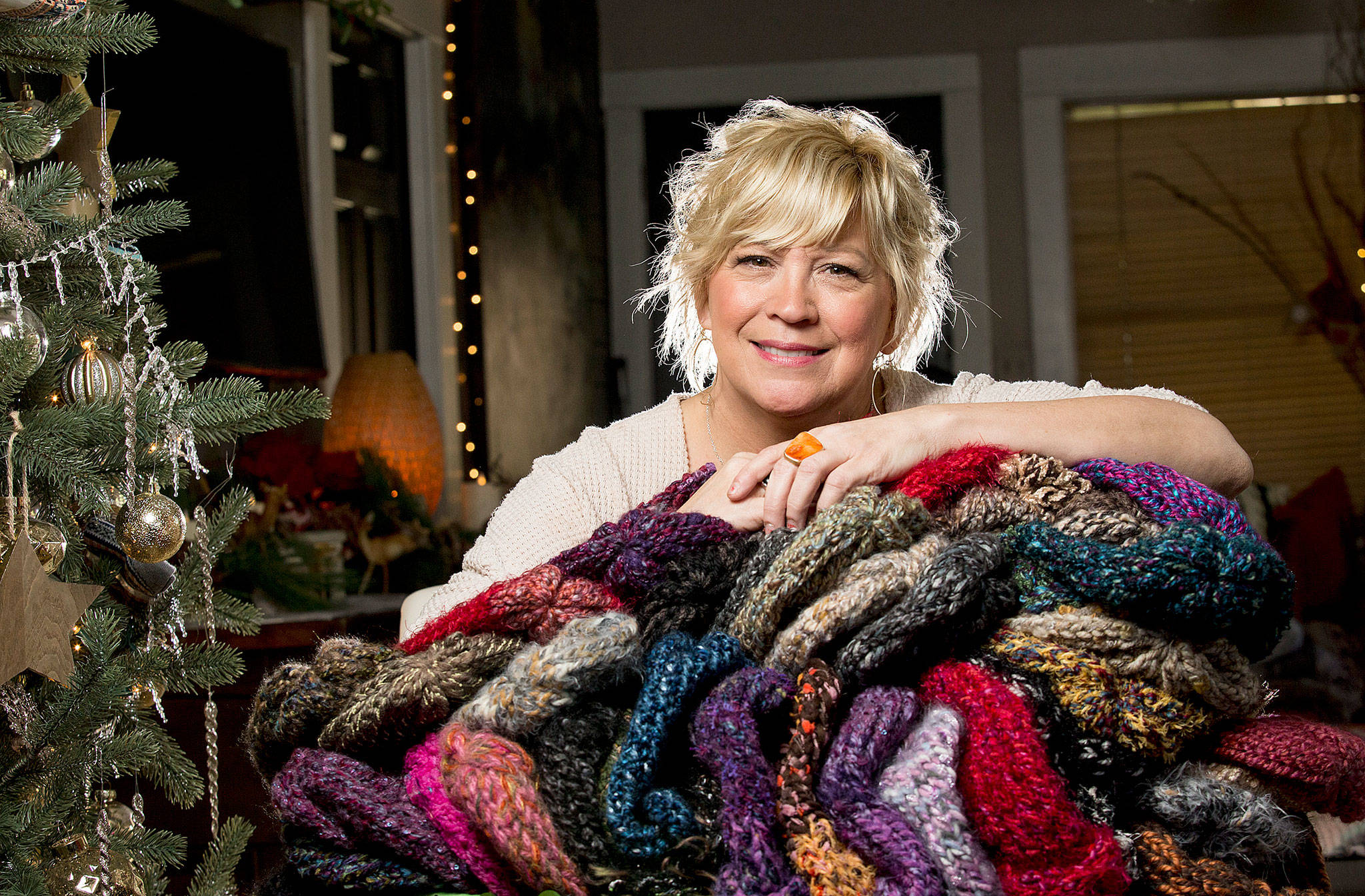 Snohomish artist Jackie Cort holds handmade hats for her annual sock-hat-scarf collection for two social service agencies in Everett. Cort, who gets hundreds of items every year from artists and friends, is having a donation drop-off night Friday that is open to the community. She started the mission some 20 years ago when her kids were little. They still help her with the project.