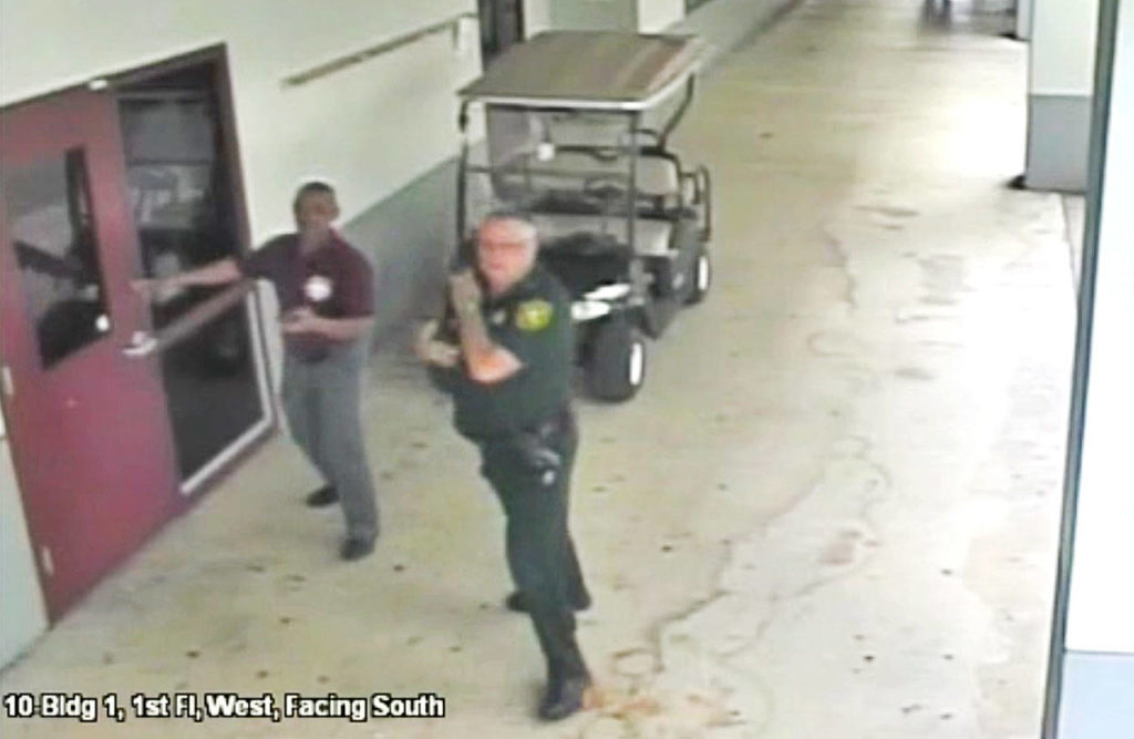 This Feb. 14, 2018, frame from security video provided by the Broward County Sheriff’s Office shows deputy Scot Peterson, right, outside Marjory Stoneman Douglas High School in Parkland, Fla. The video released Thursday, March 15, shows Peterson going toward the high school building while a gunman massacred 17 students and staff members, but stayed outside with his handgun drawn. (Courtesy of the Broward County Sheriff’s Office via AP)
