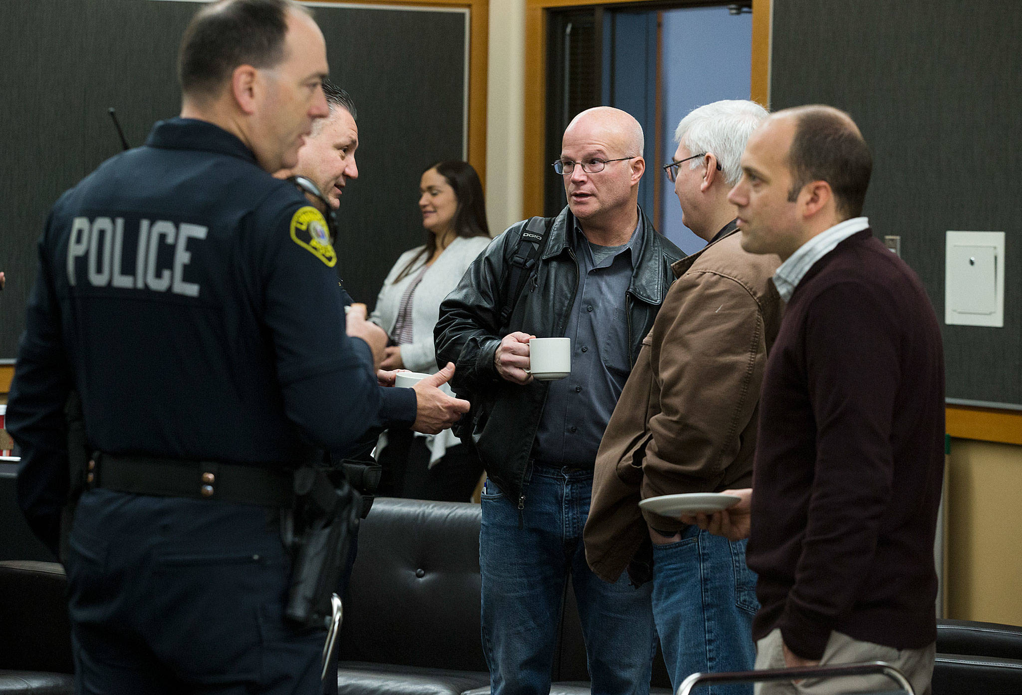 Lynnwood Police Department Commander Rodney Cohnheim, (second from left) talks with Pastors Thame Fuller, center, and Kent Landrum during the Cops and Clergy meeting Wednesday, Dec. 5, at the Lynnwood Convention Center. (Andy Bronson / The Herald)