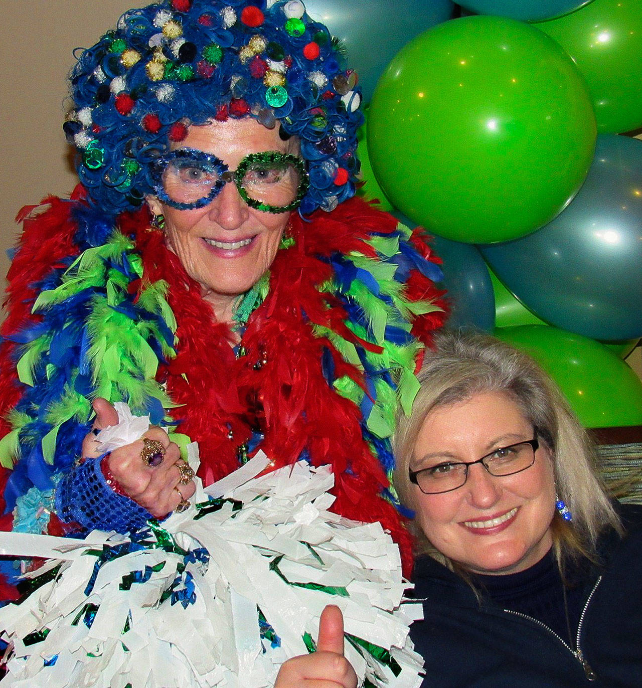 The Seahawks’ NFL Hall of Fame Fan, Patti Hammond, as “Mama Blue” (left), joins up with Suzanne Perkins Newman, who founded 12 Days of Goodness. The program brings former Seahawk players together with elders at senior centers and retirement communities. (Contributed Photo)