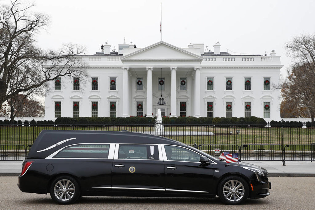 The hearse carrying the flag-draped casket of former President George H.W. Bush passes by the White House from the Capitol, heading to a State Funeral at the National Cathedral on Wednesday in Washington. AP Photo/Jacquelyn Martin)
