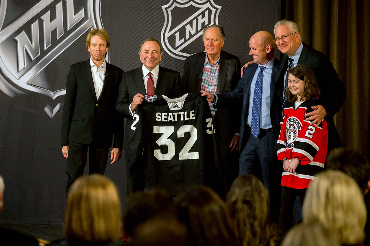 NHL commissioner Gary Bettman holds a jersey after the NHL Board of Governors announced Seattle as the league’s 32nd franchise Tuesday in Sea Island Ga. Joining Bettman, from left to right, are Jerry Bruckheimer, David Bonderman, David Wright, Tod Leiweke and Washington Wild youth hockey player Jaina Goscinski. (AP Photo/Stephen B. Morton)