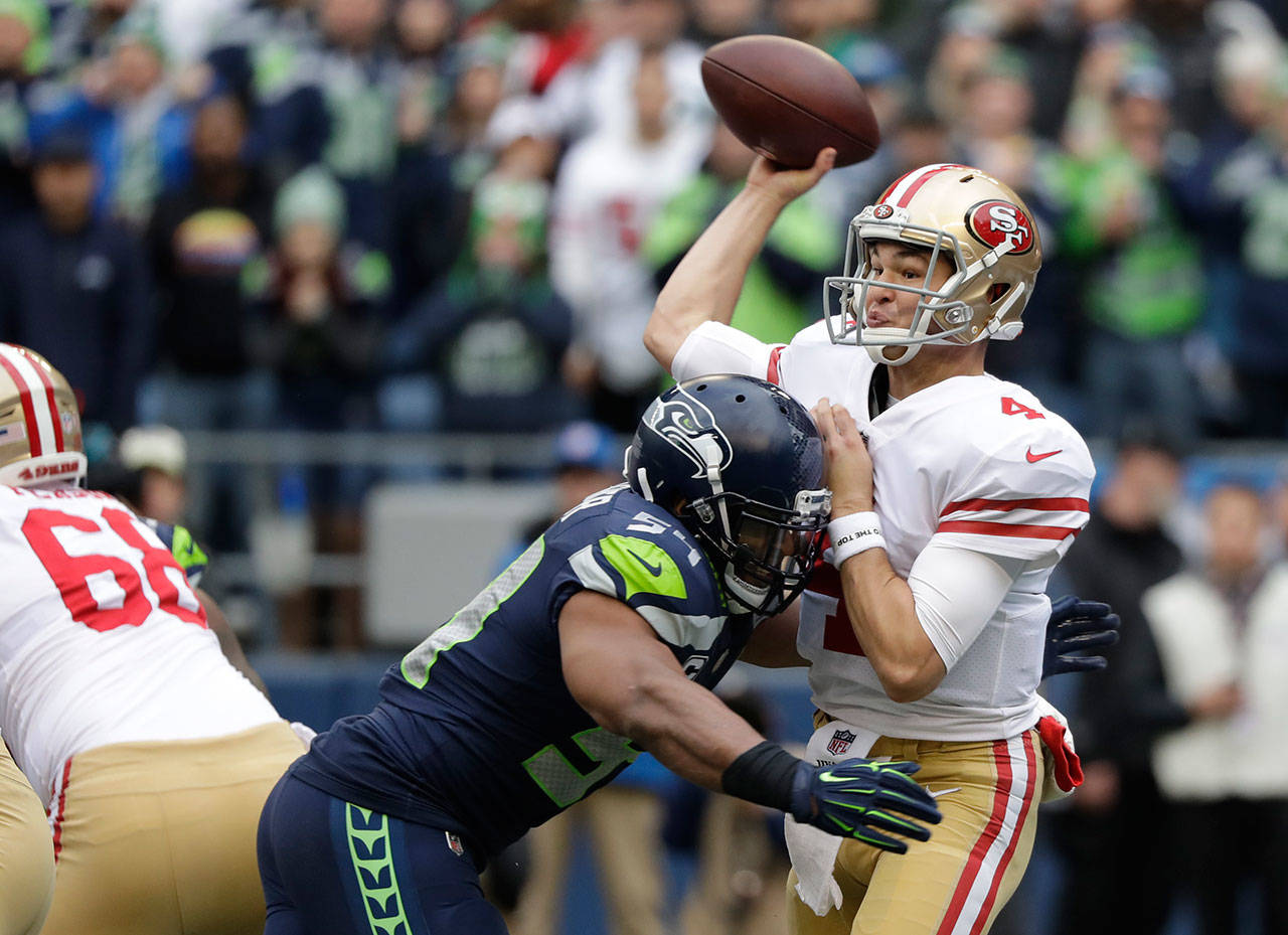 49ers quarterback Nick Mullens passes under pressure from Seahawks middle linebacker Bobby Wagner during the first half of a game on Dec. 2, 2018, in Seattle. (AP Photo/Elaine Thompson)