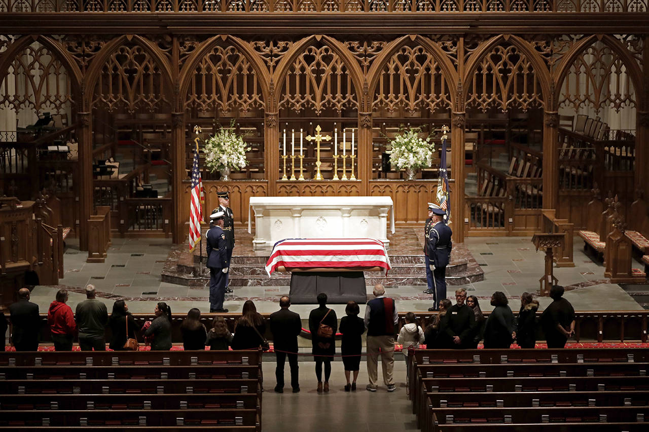 Visitors pay their respects to the flag-draped casket of former President George H.W. Bush at St. Martin’s Episcopal Church on Wednesday in Houston. (AP Photo/Mark Humphrey)