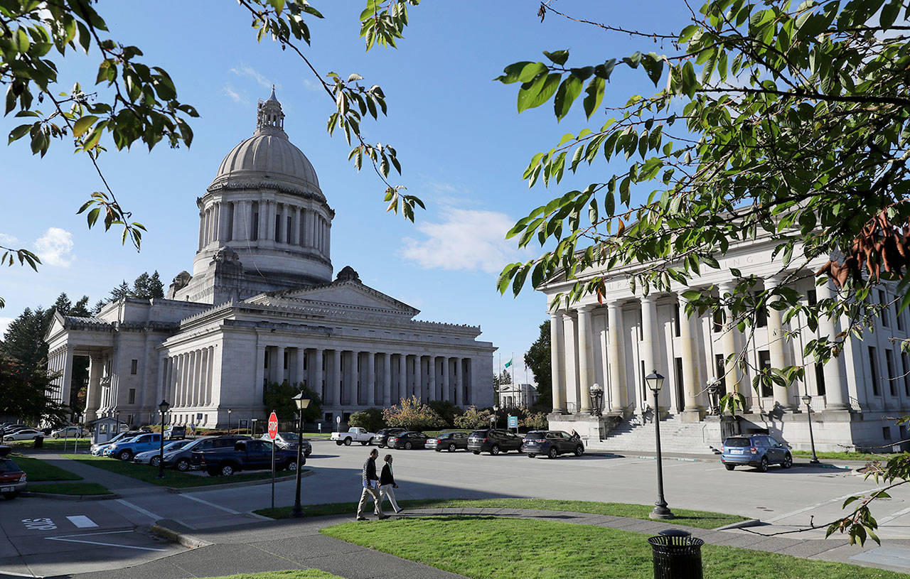 Afternoon sun illuminates the Legislative Building (at left) and the Insurance Building at the Capitol in Olympia in October. (Ted S. Warren / Associated Press)