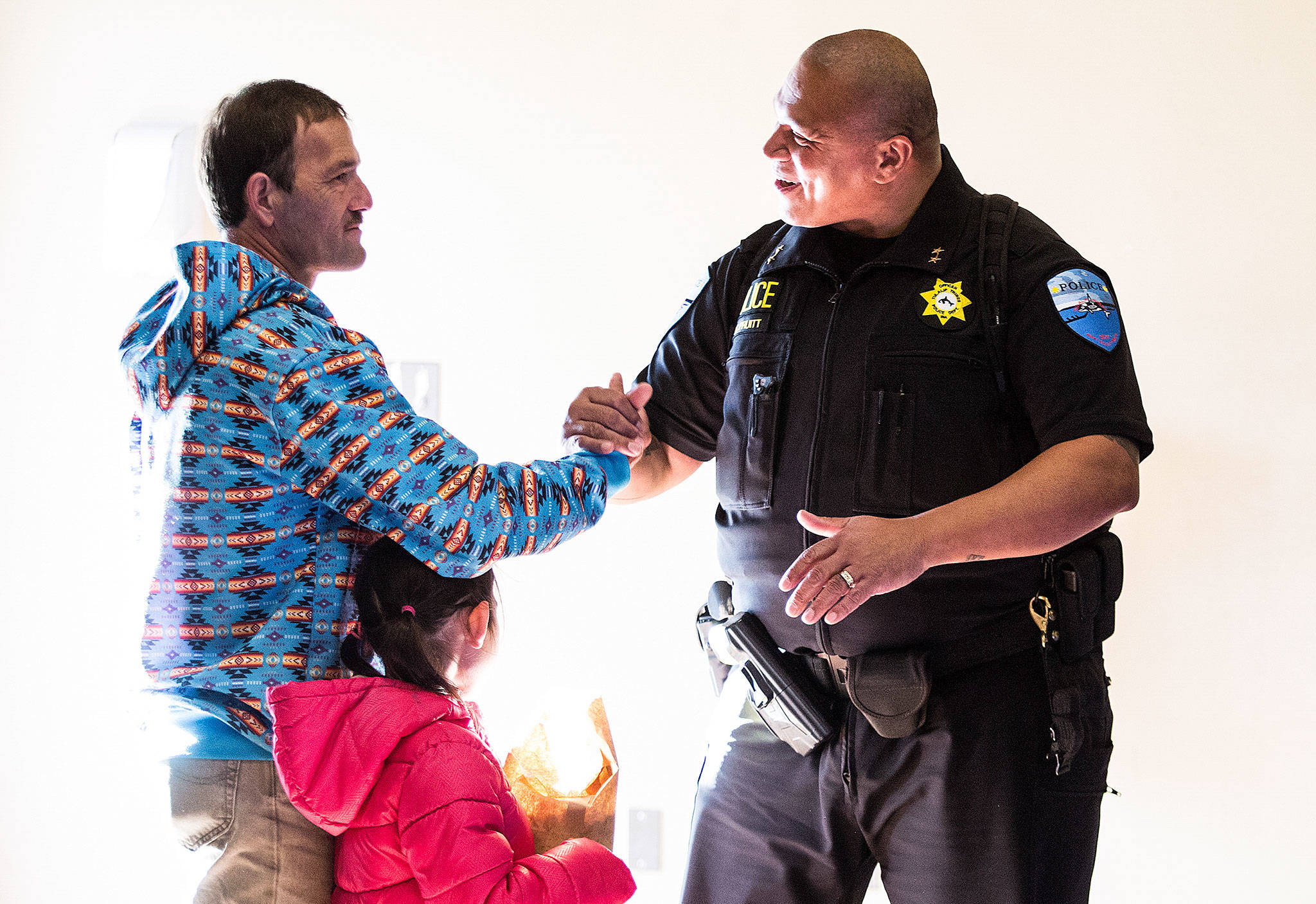 At the Don Hatch Youth Center, Verle Smith shakes hands with Tulalip Tribes Police Department Deputy Chief Sherman Pruitt before Smith is honored, by friends and family, as the first graduate from the Tulalip Healing to Wellness Court on Monday, Dec. 10, 2018 in Tulalip Reservation, Wa. (Andy Bronson / The Herald)