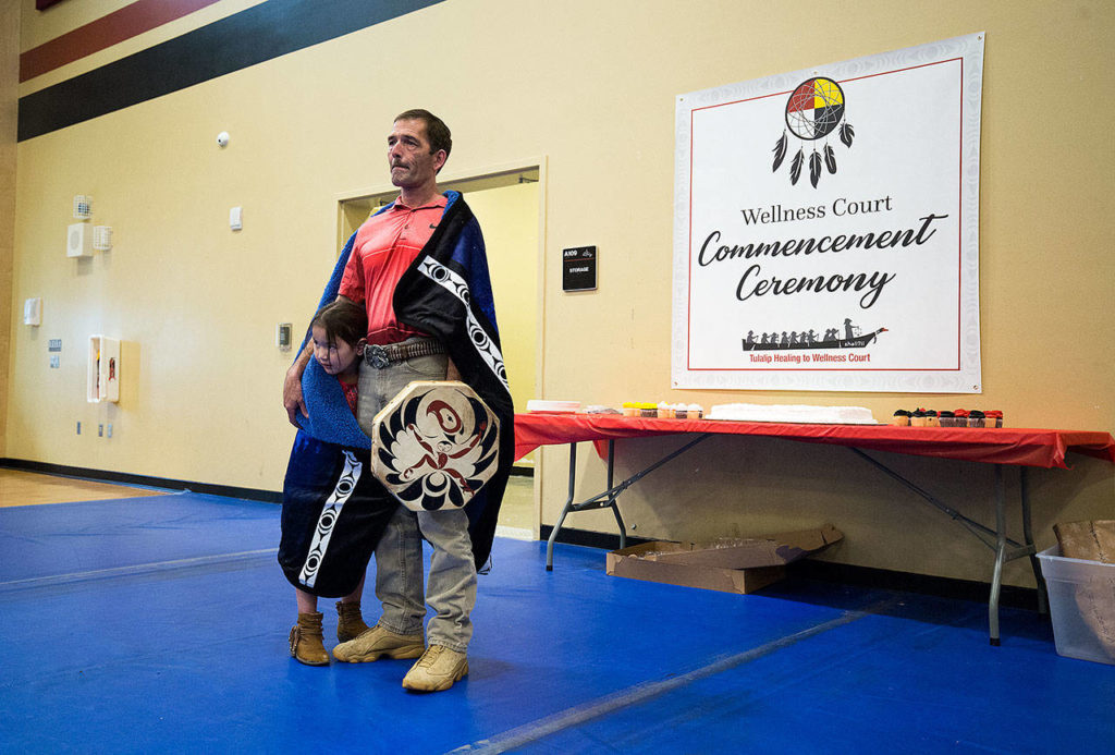 At the Don Hatch Youth Center, Verle Smith starts to tear up while friends and family congratulate him as the first graduate from the Tulalip Healing to Wellness Court, on Monday, Dec. 10, 2018 in Tulalip Reservation, Wa. His daughter Melody, 5, hides under a blanket, presented to him for graduating the program. (Andy Bronson / The Herald)
