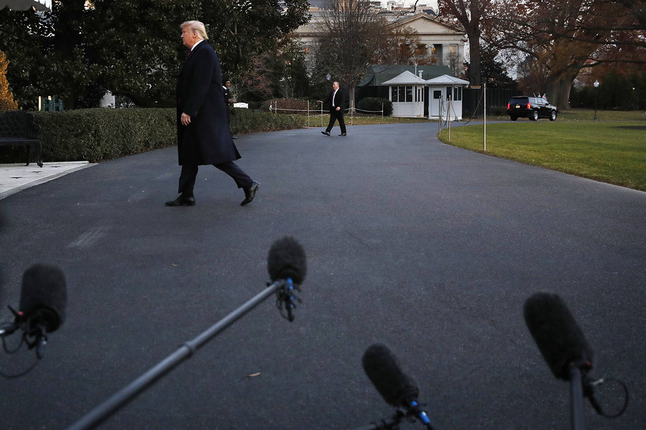 President Donald Trump walks past waiting microphones as he returns to the White House on Friday. (AP Photo/Jacquelyn Martin)