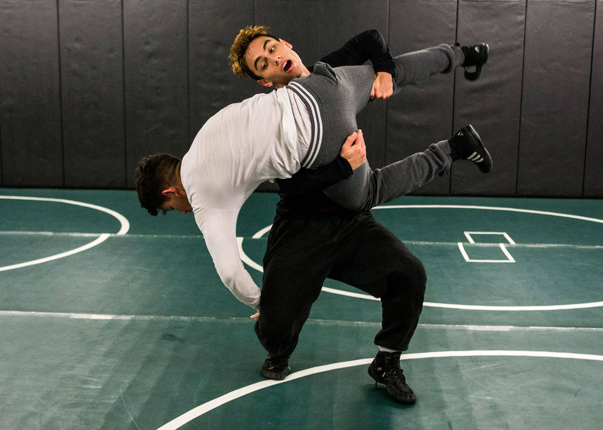 Marysville Getchell’s Trey Padgett lifts training partner Jesus Cabadas during a lift-and-return drill during a team practice Dec. 11 Marysville. (Olivia Vanni / The Herald)