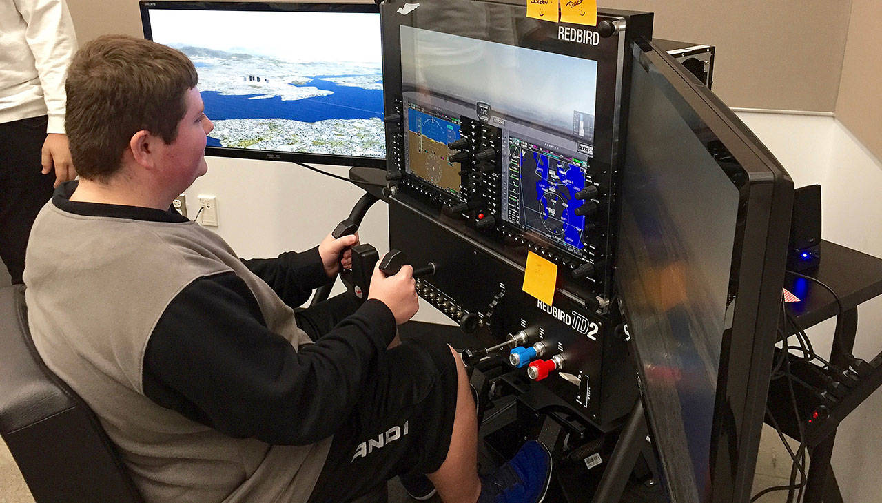 North Creek High School junior Austin Mitchell learns to fly using a $14,000 Redbird flight simulator in Northshore School District’s new Introduction to Aviation class. (Northshore School District)