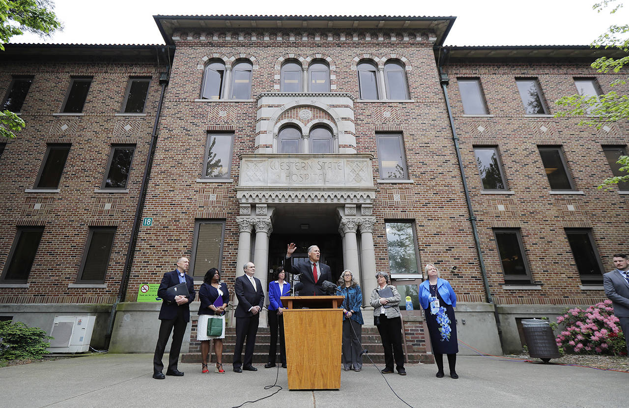In this May 11 photo, Gov. Jay Inslee (center) speaks in front of Western State Hospital in Lakewood. (AP Photo/Ted S. Warren, File)