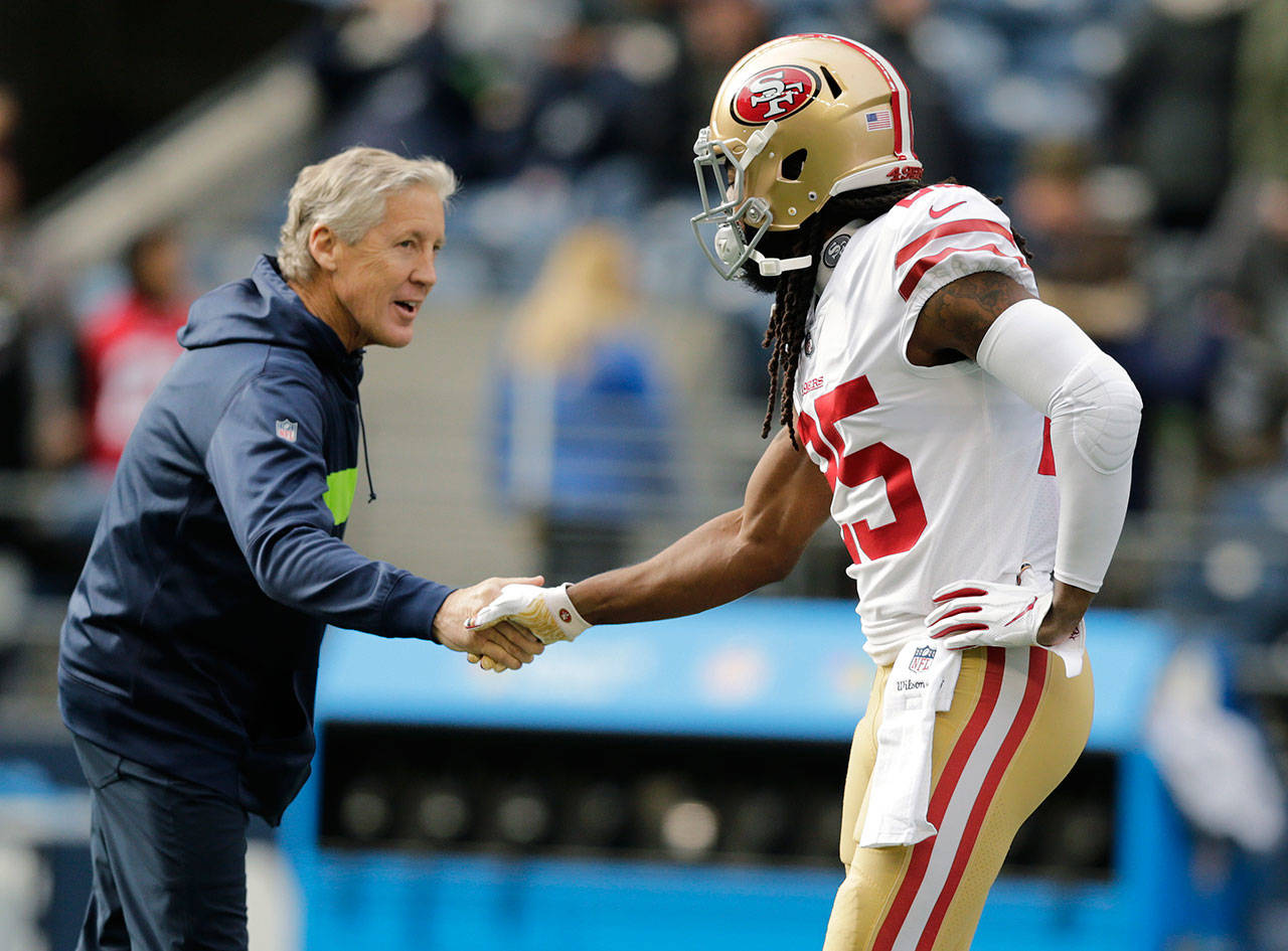 49ers cornerback Richard Sherman (right) shakes hands with Seahawks head coach Pete Carroll before a game on Dec. 2, 2018, in Seattle. (AP Photo/John Froschauer)