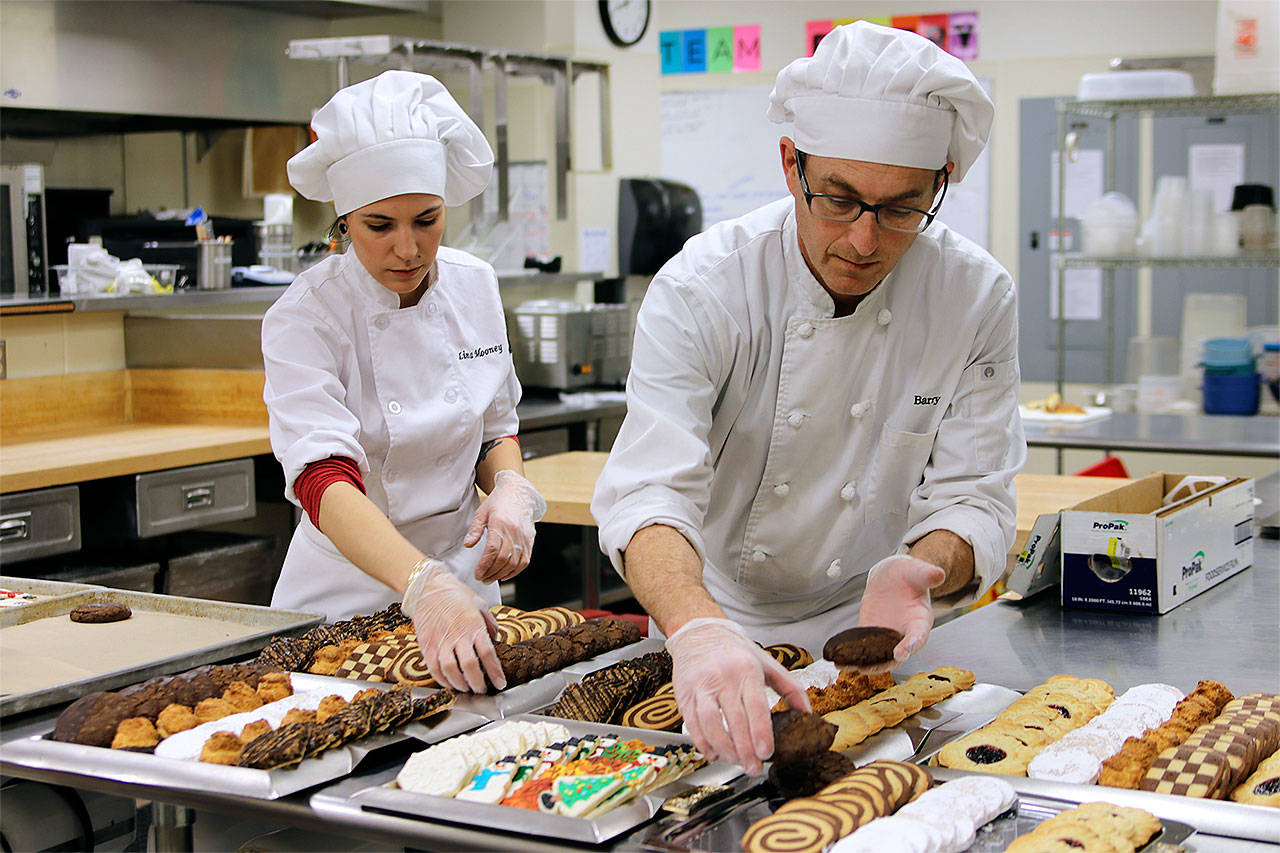 Edmonds Community College Baking and Pastry Arts students Carolina Mooney (left) and Barry Rickman prepare cookies for donation to the Seattle Milk Fund’s annual CookieFest. (Contributed photo)