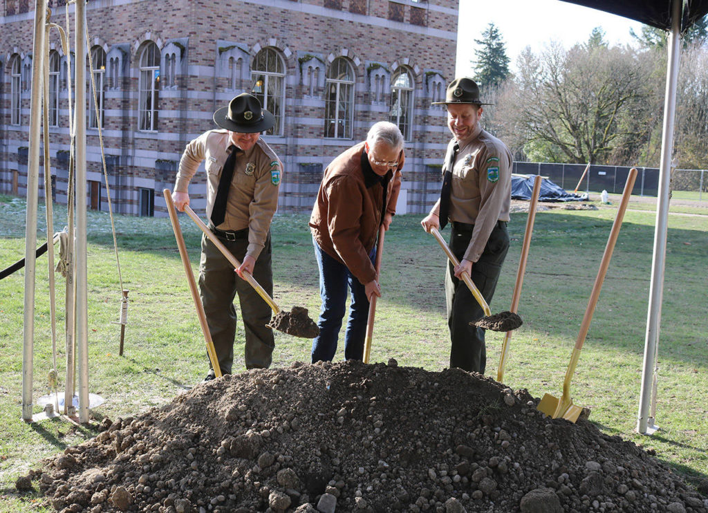 Kevin Daniels of Daniels Real Estate helps state park rangers shovel dirt at the ceremonial groundbreaking for the Lodge at Saint Edward Park on Dec. 7. His company is restoring and renovating the seminary building in the park. (Katie Metzger / Bothell-Kenmore Reporter)
