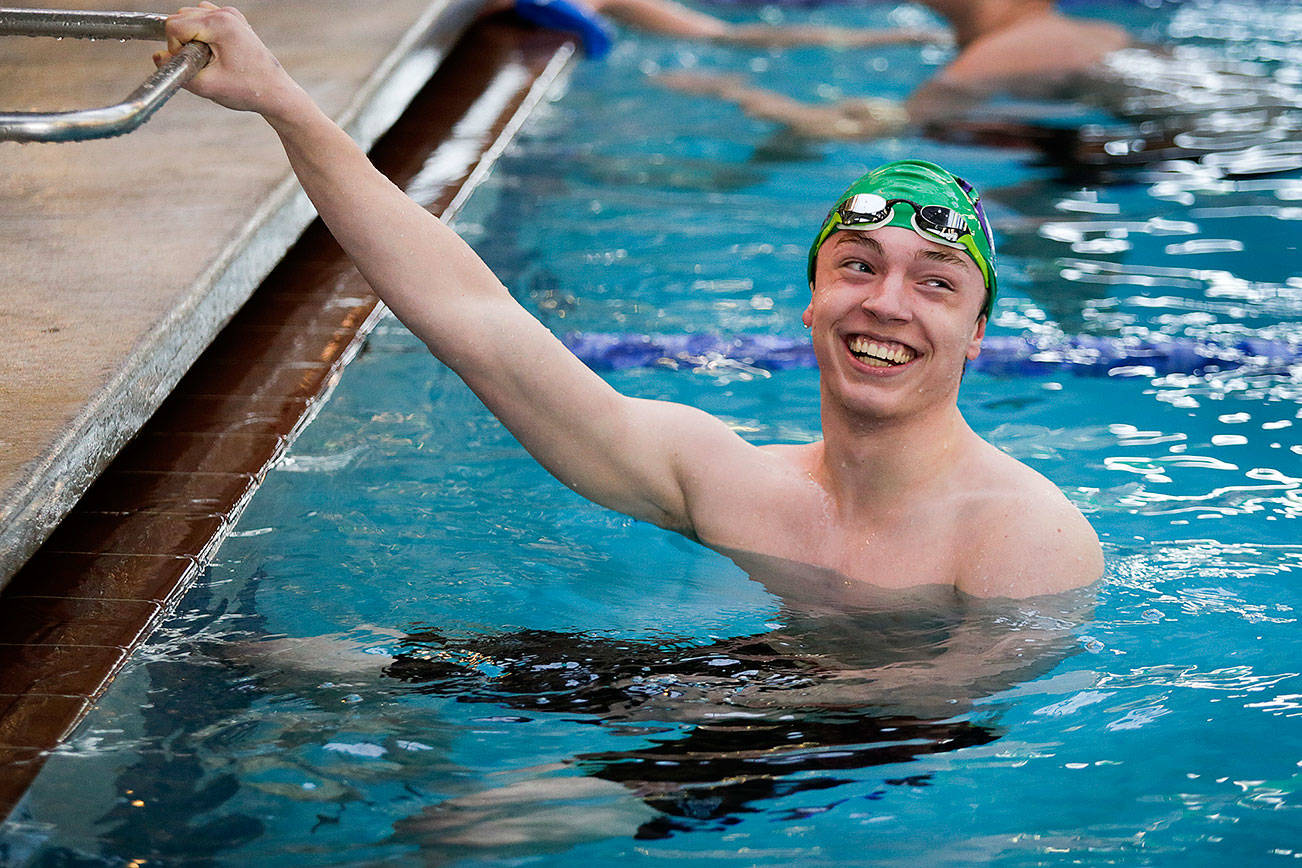 Edmonds-Woodway senior Daniel Eno smiles at teammates after winning his race at the Lynwood Pool on Tuesday, Dec. 18, 2018 in Lynnwood, Wa. Eno has qualified for the 3A state meet in each of the last two seasons and hopes to qualify in multiple events for this season’s state meet. He’s also a world traveler, can speak multiple languages and is accomplished student (he’s a member of Edmonds-Woodway’s International Baccalaureate program).(Andy Bronson / The Herald)