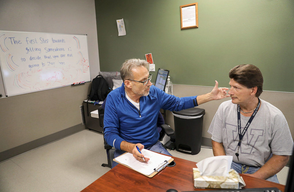 Geoffrey Godfrey (left), a nurse practitioner at Ideal Option, counsels Curtis Letzkus, who was connected to the addiction medicine clinic through the Snohomish County Jail. (Lizz Giordano / The Herald)
