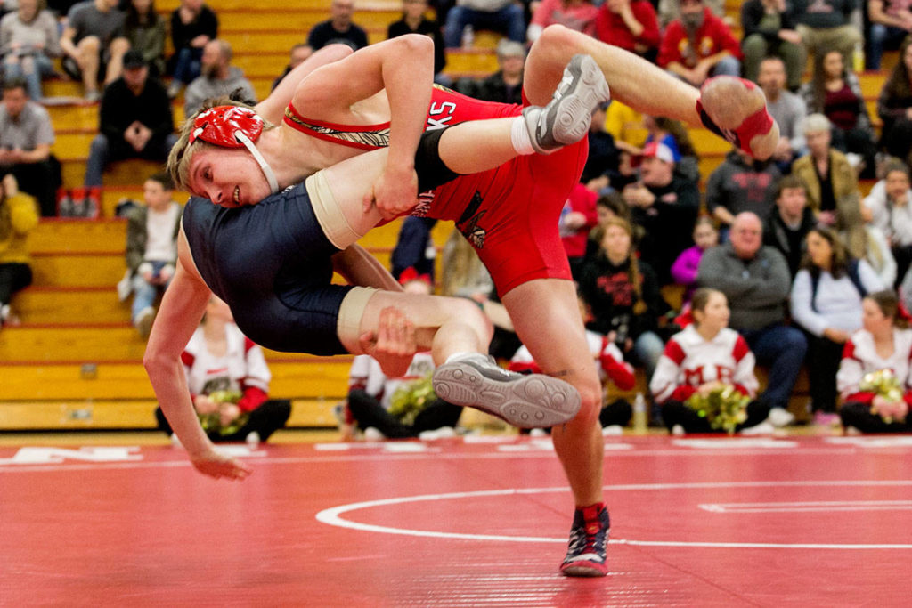 Marysville Pichuck’s Austin Davis (right) drops Arlington’s Todd Smith to the mat during a Jan. 25 match in Marysville. Davis and the Tomahawks clinched the Wesco 3A North title with the win. (Kevin Clark / The Daily Herald)
