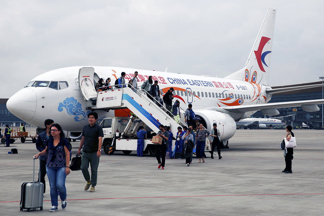Airline passengers exit a Boeing 737 operated by China Eastern Airlines at Kunming Changshui International Airport in Kunming, Yunnan province, China, on Aug. 21, 2016. (Luke MacGregor/Bloomberg)