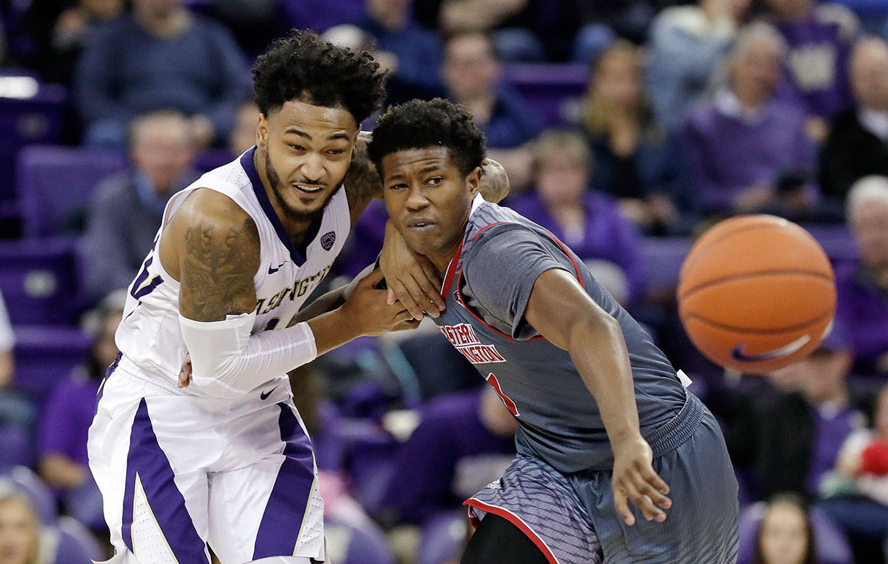 Washingtons David Crisp (left) and Eastern Washingtons Austin Fadal collide as they chase a loose ball during a game on Nov. 27 in Seattle. (AP Photo/Elaine Thompson)