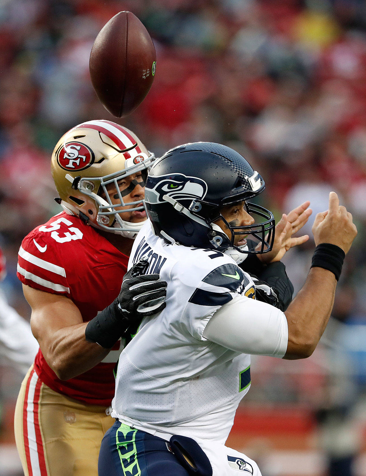 Seattle Seahawks quarterback Russell Wilson fumbles as he is sacked by San Francisco 49ers outside linebacker Mark Nzeocha (53) during the second half of Sunday’s game in Santa Clara, California. Wilson recovered the ball. (AP Photo/Tony Avelar)