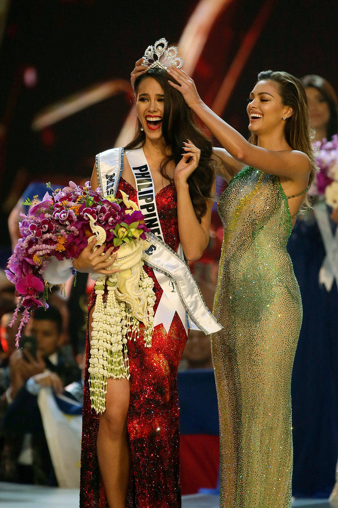 Miss Universe 2017 Demi-Leigh Nel-Peters, of South Africa (right), crowns new Miss Universe Catriona Gray, of Philippines, during the final of 67th Miss Universe competition Monday in Bangkok, Thailand.(AP Photo/Gemunu Amarasinghe)