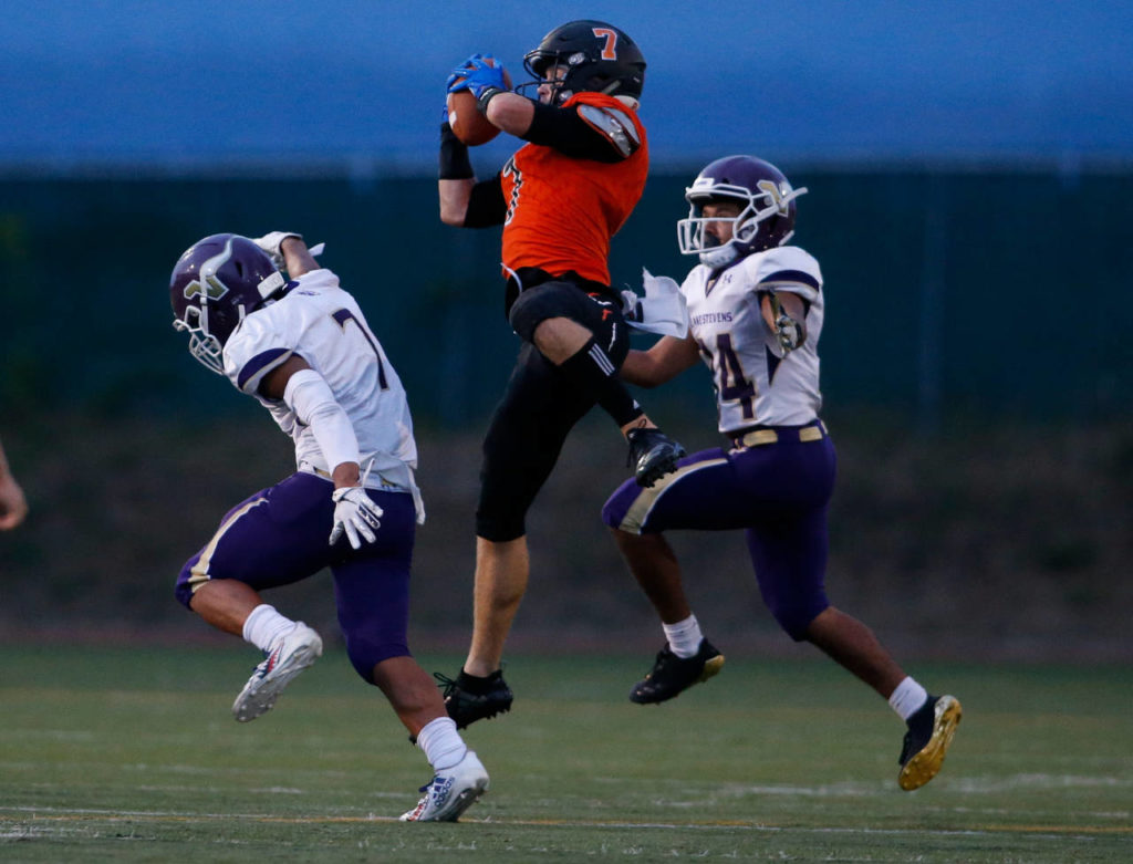 Monroe’s Efton Chism hauls in a pass between two defenders as Lake Stevens led Monroe 35-14 late in the second quarter Sept. 14, in Monroe. (Andy Bronson / The Herald)
