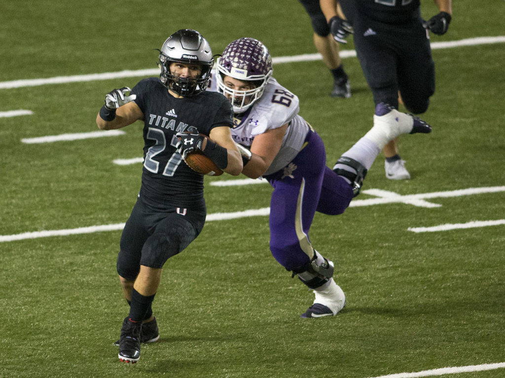 Lake Stevens’ Devin Kylany tries to bring down Union’s Alex Vallejo after a fumble recovery in the first half of the 4A high school football championship, Dec. 1, in Tacoma. (Andy Bronson / The Herald)
