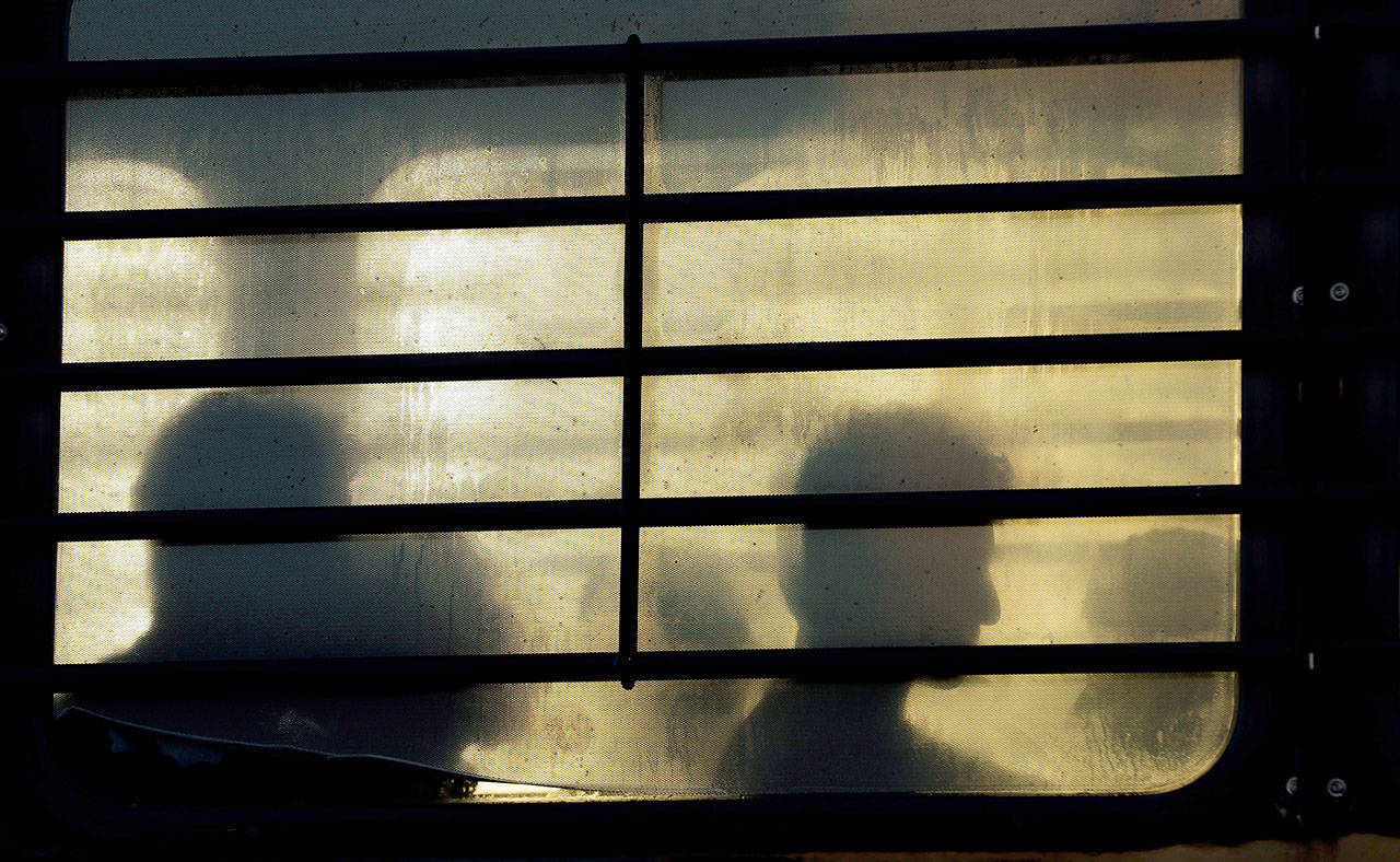 Immigrants who entered the United States illegally wait to board a plane for a deportation flight to El Salvador by U.S. Immigration and Customs Enforcement in Houston on Nov. 16. An obscure division of U.S. Immigration and Customs Enforcement operates hundreds of flights each year to remove immigrants. (AP Photo/David J. Phillip)