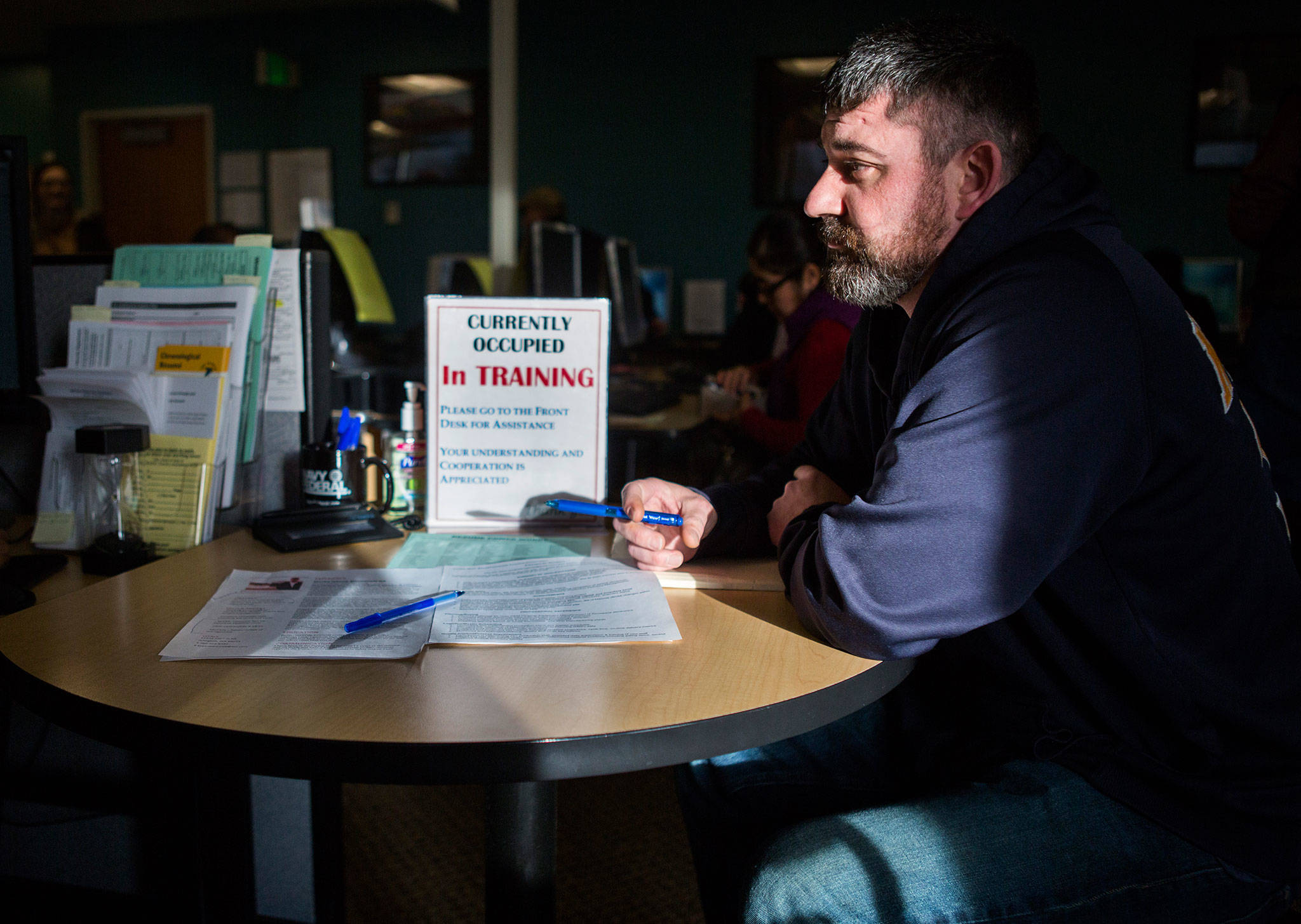 Bryan Barnwell gets help with his resume at the WorkSource office in Everett Station on Dec. 7. (Olivia Vanni / The Herald)