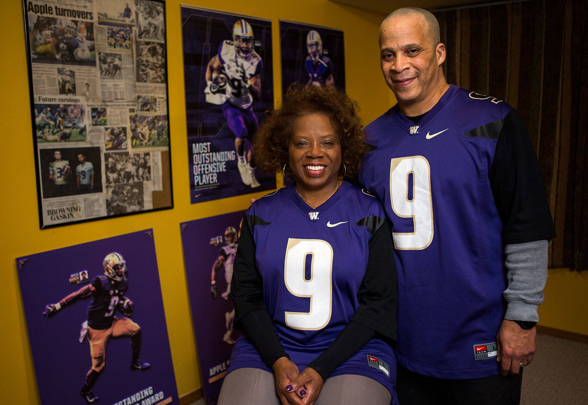 Robbie and Scott Gaskin, parents of University of Washington Husky football running back Myles Gaskin, stand near some memorabilia of his record-setting career at their home in Lynnwood. The family is in Pasadena this week to watch him play in the Rose Bowl. (Olivia Vanni / The Herald)