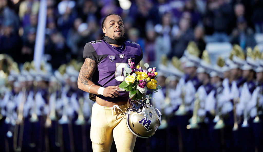 Washington’s Myles Gaskin runs past the Husky Marching Band as he is introduced with other seniors before an NCAA college football game against Oregon State on Nov. 17 in Seattle. (Elaine Thompson / AP file)
