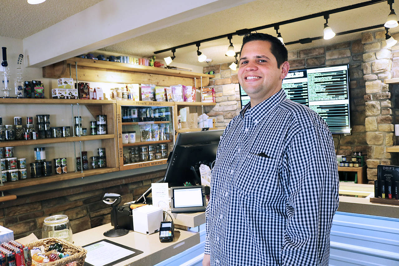 Aaron Nelson, CEO of 2020 Solutions, stands in front of the new credit card system in the Iron Street location. (Emily Hamann / Bellingham Business Journal)