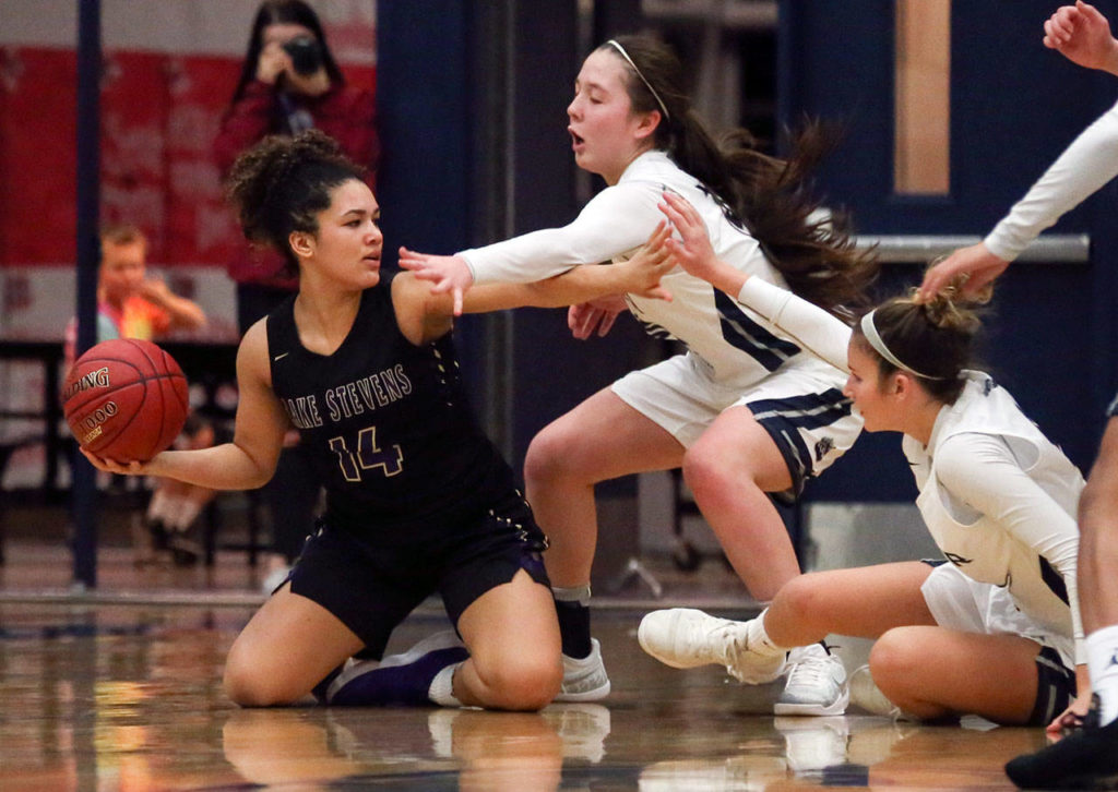 Lake Stevens’ Baylor Thomas looks to pass wth Glacier Peak’s Maya Erling defending Tuesday night at Glacier Peak High School in Snohomish on December 18, 2019. Glacier Peak won 68-50. (Kevin Clark / The Herald)
