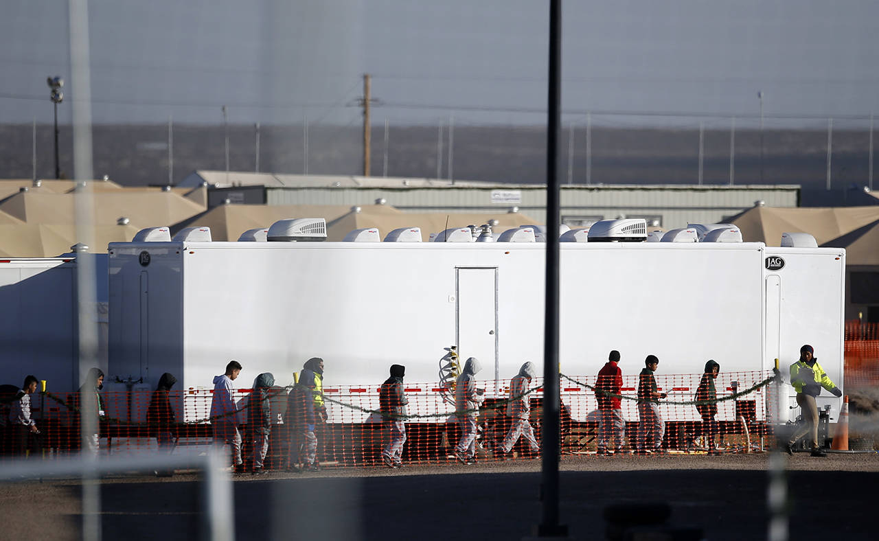 Migrant teens walk in a line through the Tornillo detention camp in Tornillo, Texas, on Thursday, Dec. 13. (AP Photo/Andres Leighton)