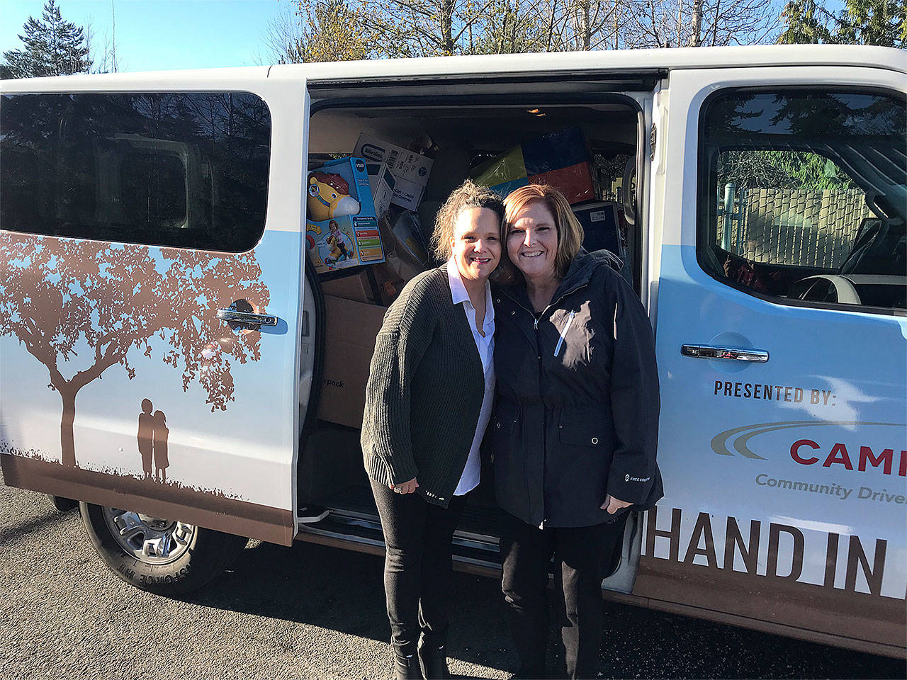Shannon Skartved with The Everett Clinic (left) stands in front of one of six trucks full of donations with Alice Casson of Hand in Hand. (Contributed photo)
