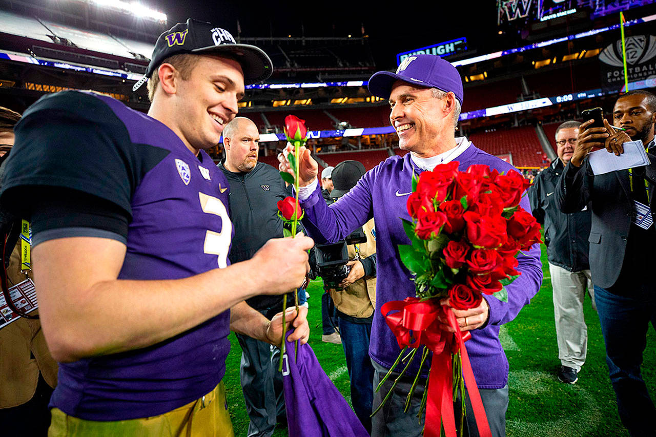 Chris Petersen presents Jake Browning with two roses after Washington defeated Utah to get into the Rose Bowl. The Historic Everett Theatre and Edmonds Theater are hosting free viewing parties of the Washington vs. Ohio State game on New Year’s Day. (Seattle Times file)