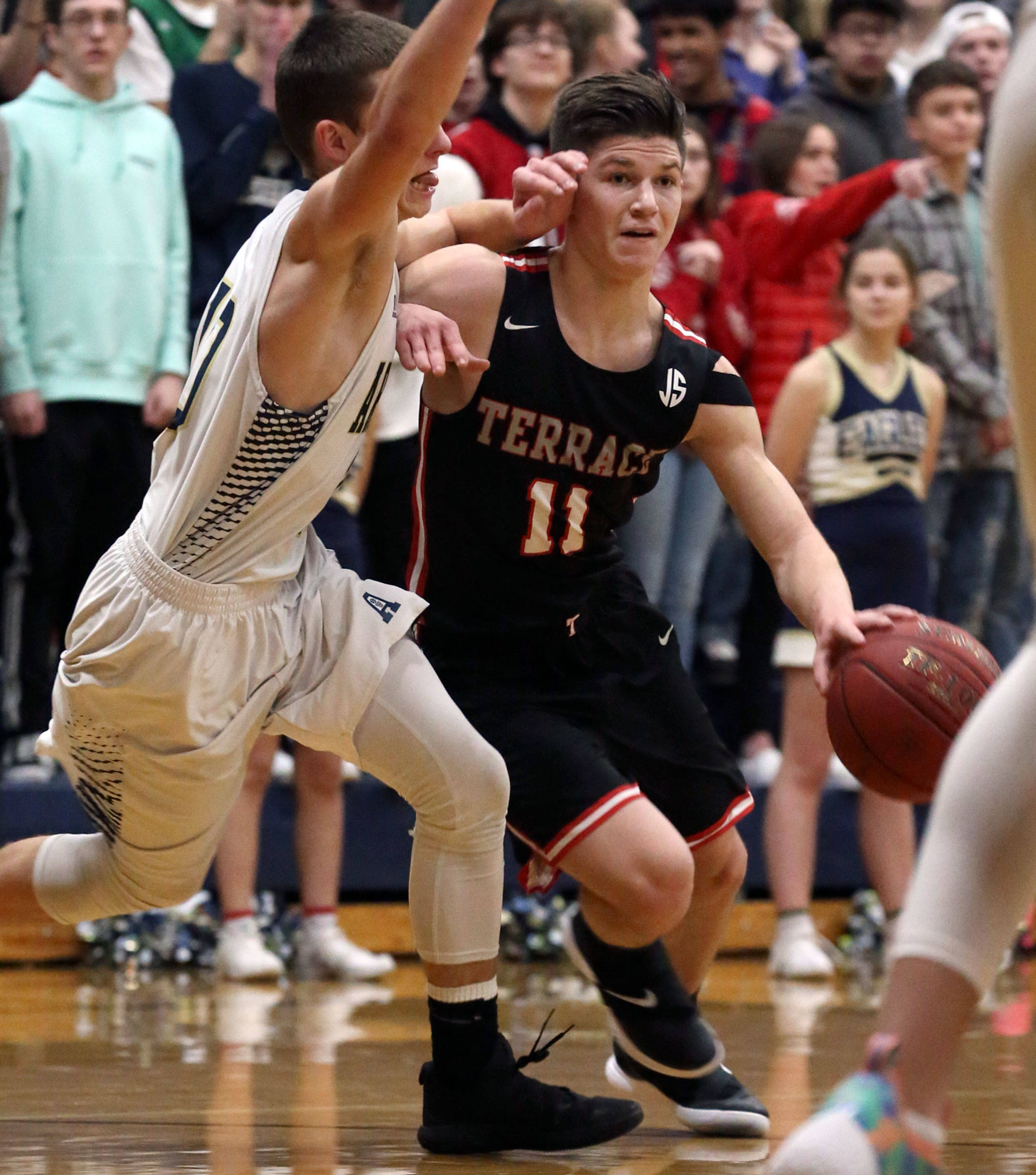 Mountlake Terrace’s Mason Christianson drives the lane with Arlington’s Anthony Whitis defending Friday night at Arlington High School. Mountlake Terrace won 69-67. (Kevin Clark / The Herald)