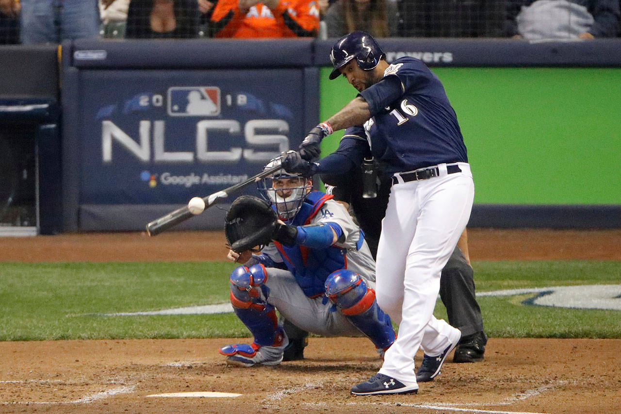 The Brewers’ Domingo Santana hits a two-run double during Game 1 of the National League Championship Series against the Dodgers on Oct. 12, 2018, in Milwaukee. The Mariners acquired Santana on Friday. (AP Photo/Charlie Riedel)