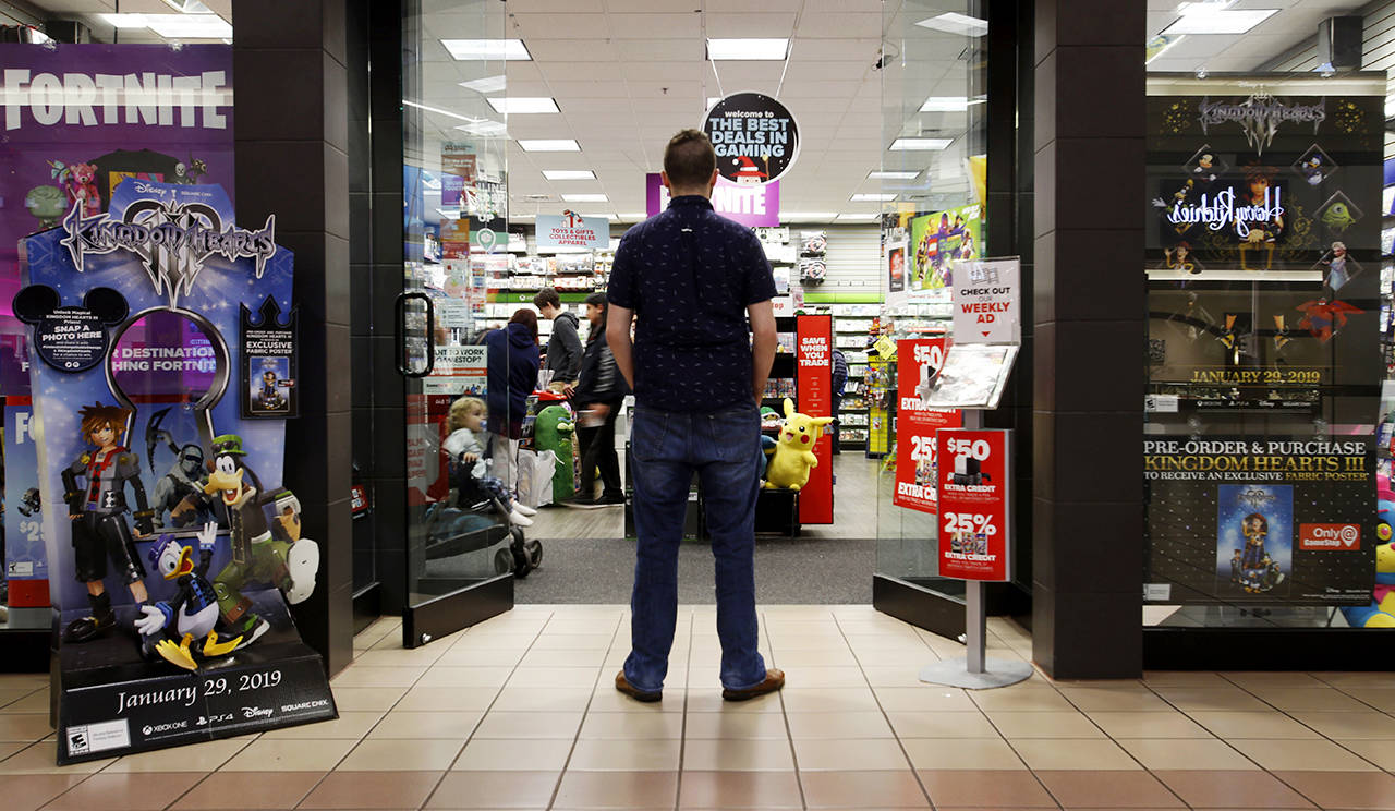 A 27-year-old self-described tech addict poses for a portrait in front of a video game store at a mall in Everett. (AP Photo/Martha Irvine)