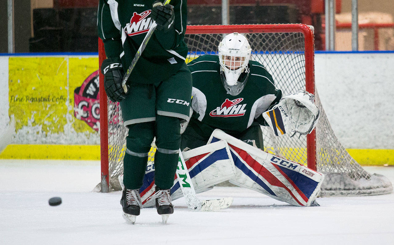 Goalie Blake Lyda tries to keep an eye on the puck as a defender moves out of the way of the shot during a Silvertips practice on Sept. 20, 2018, in Everett. (Andy Bronson / The Herald)