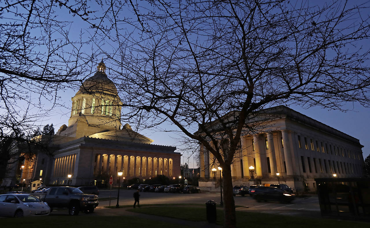 This Dec. 4 photo shows the Legislative (left) and Insurance buildings at dusk at the Capitol in Olympia. (AP Photo/Ted S. Warren)