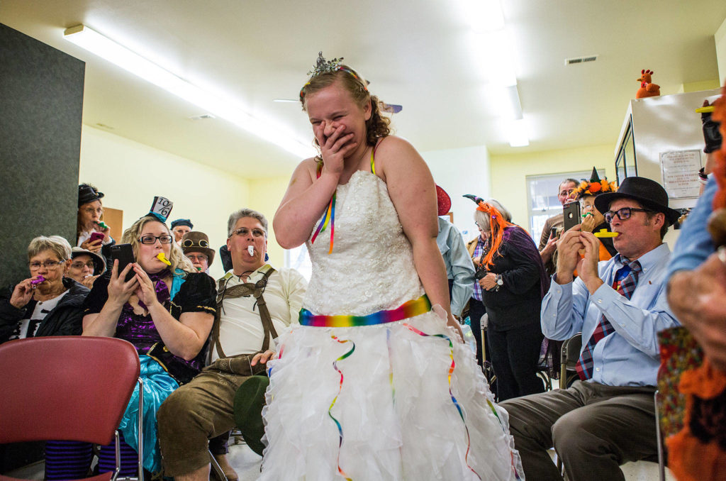 Kira Day laughs as she walks down the aisle to a kazoo version of “Here Comes the Bride” during her Halloween wedding at the Snohomish Community Food Bank on Oct. 27 in Snohomish. (Olivia Vanni / The Herald)
