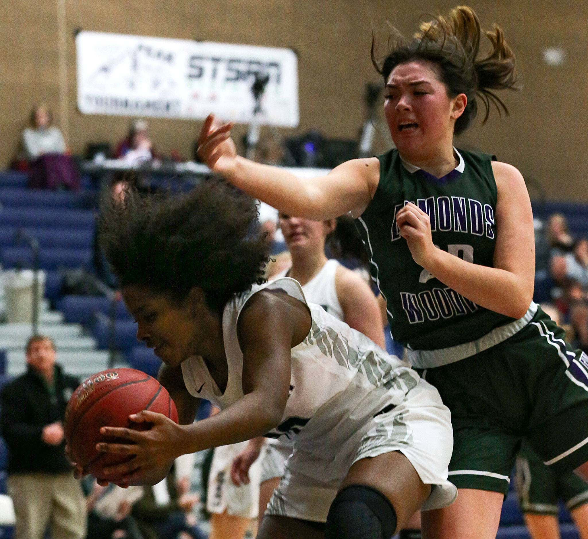Chiawana’s Mykila Burton pulls down a rebound in front of Edmonds-Woodway’s Maddie McMahon during the Top of the Peak Tournament on Thursday at Glacier Peak High School in Snohomish. Chiawana won 60-43. (Kevin Clark / The Herald)