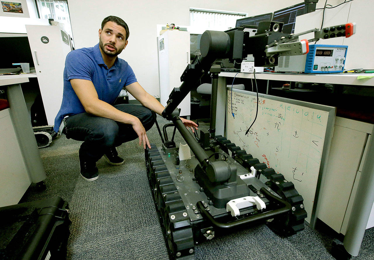 Software engineer Nicholas Otero speaks with a colleague about features of a Centaur robot at Endeavor Robotics in Chelmsford, Massachusetts, on Aug. 28. (AP Photo/Steven Senne)