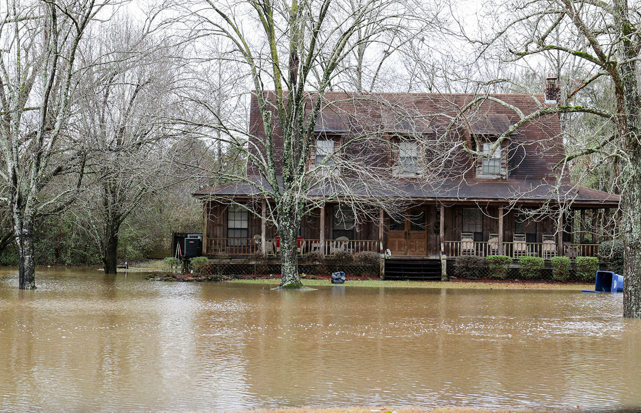 Flood waters begin to approach a home Friday near Highway 19 North in Meridian, Mississippi. Intense rains across the Deep South and heavy snow in the Upper Midwest are making a mess for post-holiday travelers. (Paula Merritt/The Meridian Star via AP)